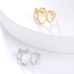 Detailsicht minimalistischer goldener und silberner ovaler Ringe auf weißem Display