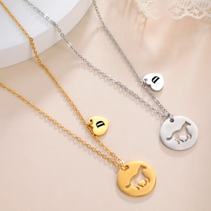 Golden and silver horse pendant necklaces with heart D charms on a minimalist stand