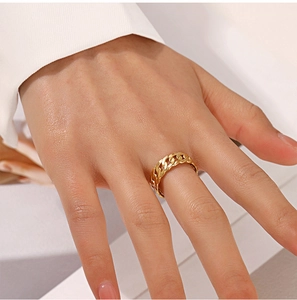 Detailed view of an 18K gold plated Cuban link chain ring worn by a model