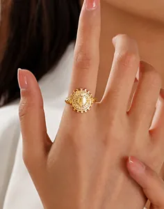 Gros plan d'une bague cœur en acier inoxydable doré avec motif soleil et anneau torsadé