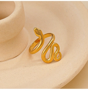 Gros plan d'une bague serpent dorée polie avec un design de corps enroulé réaliste