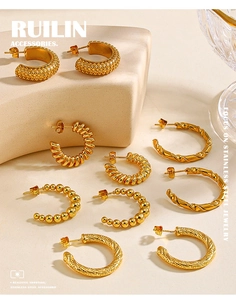 Close-up of assorted 18K gold plated stainless steel hoop earrings with textured patterns