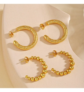 Detail view of 18K gold plated C-shaped earrings with twisted rope and beaded designs