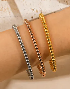 Dettaglio ravvicinato di bracciali a sfere in acciaio inox in oro, argento e oro rosa