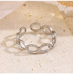 Detailed close-up of a silver geometric hollow oval link ring on a marble surface