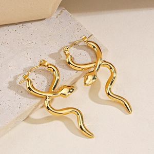 Retro golden stainless steel snake earrings set displayed on beige textured stone