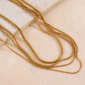 Cadenas de serpiente minimalistas de acero inoxidable dorado en varios grosores sobre piedra