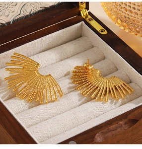 Dettaglio macro di orecchini a ventaglio placcati oro 18K con design a raggi testurizzati