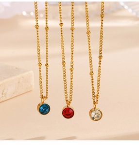 Detailed view of colorful round crystal pendants on gold beaded chains with stone accent