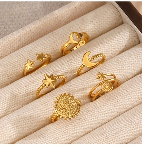 Primer plano de un juego de 6 anillos dorados con motivos de estrellas y lunas en un joyero