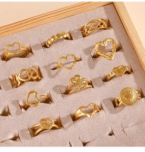 Vista detallada de 11 anillos dorados con forma de corazón en un joyero de terciopelo