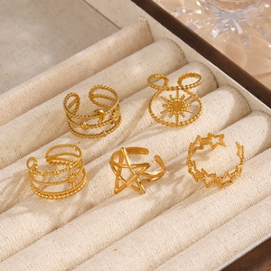 Set de cinco anillos dorados con diseños de estrella y luna en un joyero de terciopelo