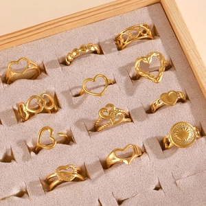 Set de 12 anillos de corazón dorados con varios diseños en una bandeja de terciopelo