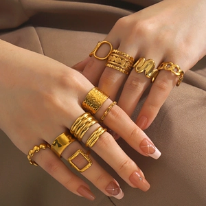 Conjunto de anillos dorados de acero inoxidable con diseños de ondas en las manos