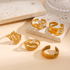Five-piece gold geometric open ring set featuring leaf and lip designs on stone texture