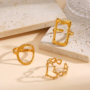 Minimalist gold geometric open rings set with hammered texture on white stone background