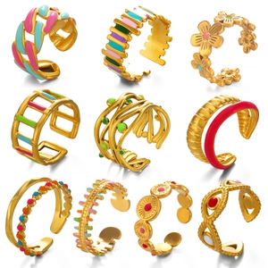 Lot de neuf bagues réglables en acier doré avec émail coloré et motifs géométriques