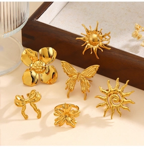 Detail von sechs goldenen Metallringen mit Sonnen-, Blumen- und Schmetterlingsmotiven