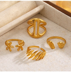 Set of four 18K gold plated rings featuring floral and textured cutout patterns
