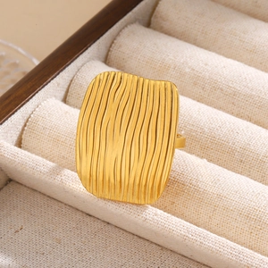 Detail of wide 18k gold plated ring with vertical wave texture in jewelry box