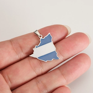 Macro shot of 18K gold Nicaragua map pendant with blue and white enamel drip details