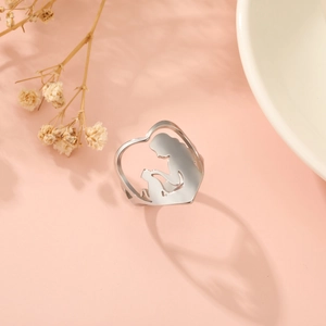 Detailed view of heart-shaped silver ring featuring a mother and child silhouette design
