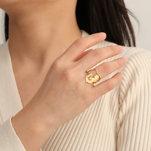 Detail of gold wide band ring with cutout heart and mother-child silhouette on model