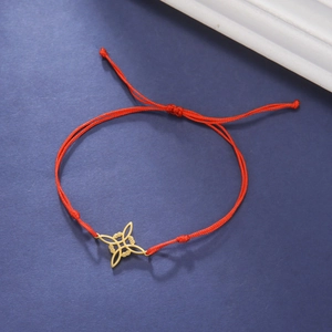 Close-up van rode gevlochten armband met 18K gouden S-vormige knoop hanger details
