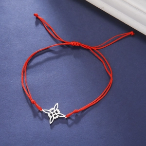 Macro detail van rode geweven armband met zilveren heksenknoop en verstelbare schuifsluiting