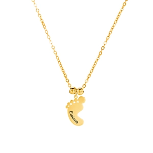 Detailopname van een gouden babyvoetje hanger met gepersonaliseerde naamgravure