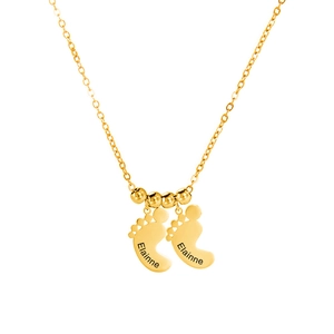Detail van gepersonaliseerde gouden babyvoetjes met Elainne gravure aan een kralenketting