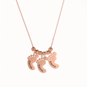 Detailweergave van roségouden babyvoetjes hangers met gepersonaliseerde naamgravure aan ketting