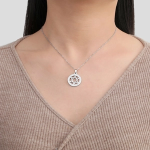 Detail of a sparkling stainless steel hexagram star pendant necklace on model