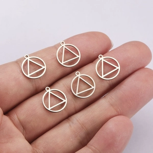 Détail de cinq mini pendentifs ronds en acier inoxydable présentés sur un doigt pour la taille