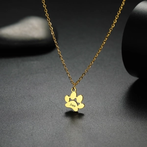 Macro shot of 18K gold plated cat paw pendant with custom Japp engraving on black stone