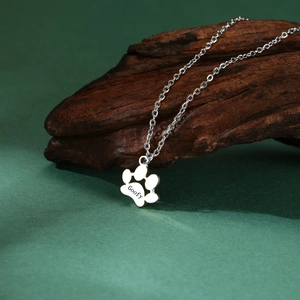 Custom silver paw print necklace with Goofy engraving on dark wood background