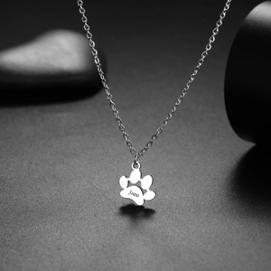 Macro detail of custom 18K gold plated cat paw pendant with Japp engraving on necklace
