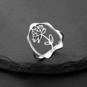 Gros plan détaillé d'une bague tournesol en argent avec gravure creuse sur une pierre sombre