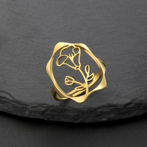Détail d'une bague fleur dorée ajourée montrant le motif floral sur une pierre