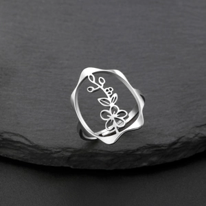 Détail d'une bague réglable en acier inoxydable argenté avec motif floral sur une pierre