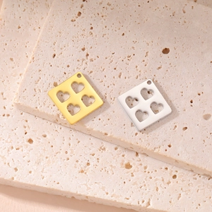 Macro detail of 18K gold plated heart cut-out square pendants for DIY jewelry