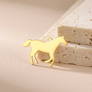 Vue macro d'un pendentif cheval au galop en acier inoxydable doré à l'or 18 carats