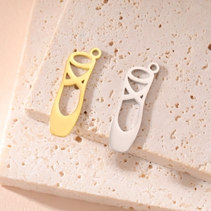 Polished stainless steel ballet slipper pendants in gold and silver finish on stone