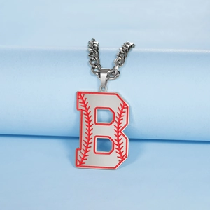 Détail macro du pendentif baseball lettre B argenté avec coutures rouges sur chaîne