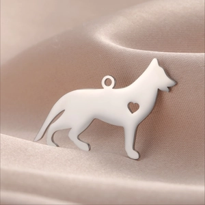 Vue macro d'un pendentif chien argenté avec découpe en cœur sur tissu en soie douce