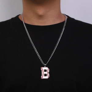 Détail du collier argenté avec pendentif lettre B style baseball sur t-shirt noir