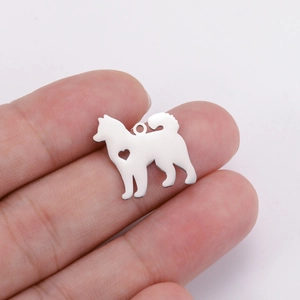 Detailed view of dog-shaped pendant in polished silver metal with heart cutout