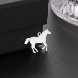 Pendentif cheval au galop en acier inoxydable poli argenté exposé sur un fond noir texturé