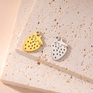 Macro detail of 18K gold and silver strawberry charms with realistic seed texture