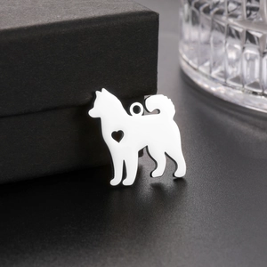 Polished stainless steel Samoyed dog pendant featuring a cutout heart detail on black background